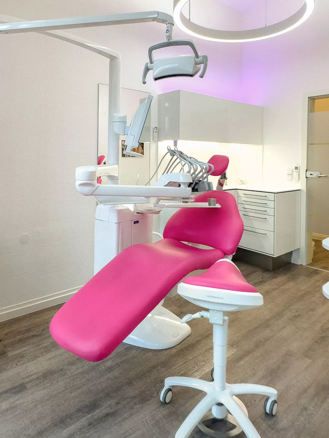 Behandlungsraum mit pinkem Behandlungsstuhl in der Praxis Joy & Smile